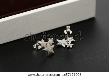 A silver earring in the shape of a five pointed star