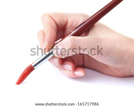 Hand holding brush with red paint isolated on white