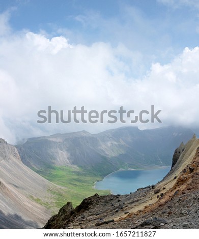 Looking down to Tianchi Heaven lake and mountains from crater edge on sunny day, Changbaishan National Park China 