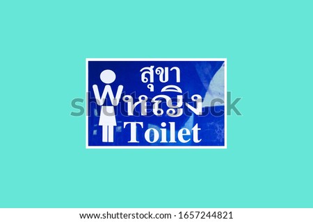 Women  or toilets. Written in Thai and English alphabet. Toilet signs for green background. Selective focus

