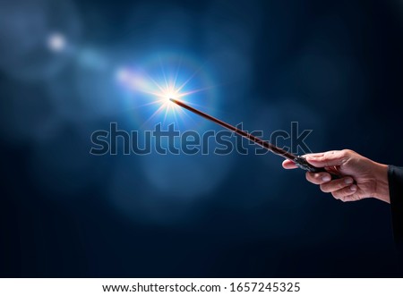 Magic wand with sparkle on blue background, Miracle magical stick Wizard tool on hot blue. Royalty-Free Stock Photo #1657245325