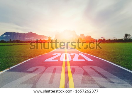 Concept new year With The word 2020 to 2021 Written on The asphalt  road in country road Decorate orange light for beauty With With views of rice fields on both sides Concept for new year of 2021 Royalty-Free Stock Photo #1657262377