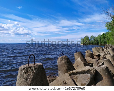concrete breakwaters, protective structures for the riverbank on a sunny day