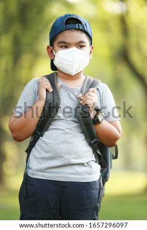 A young Asian boy , 7 Years Old , wear mask to protect against dust PM 2.5 and germs Royalty-Free Stock Photo #1657296097