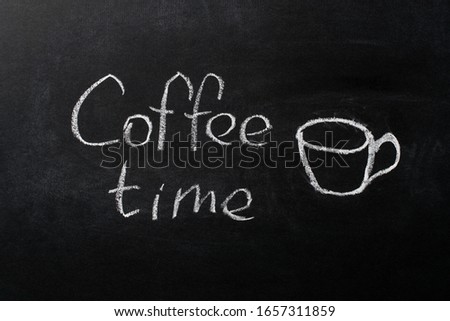 A cup drawn by white chalk on a black chalkboard. The inscription "coffee time". Copy space on the background of a black school board.