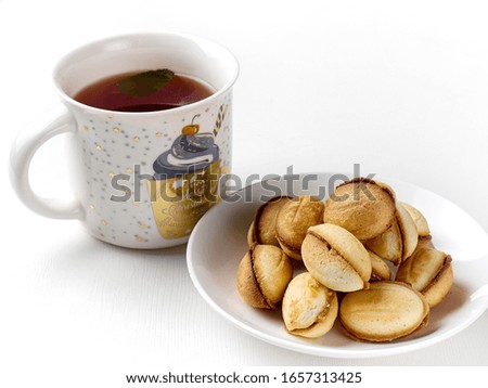 delicious walnut shaped shortbread sandwich cookies filled with sweet condensed milk and a mug of tea