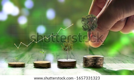 Men's hands stacked coins with the concept of saving money and with a graph of profit.