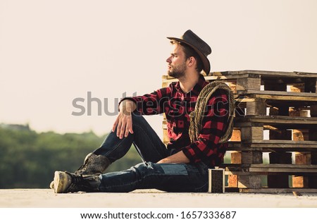 Farmer enjoy view from his farm. Romanticism of western culture. Farmer in hat sit relax. Peaceful mood. Watching sunset. Farmer cowboy handsome man relaxing after hard working day at ranch. Royalty-Free Stock Photo #1657333687