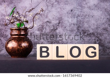 Word BLOG made with wood building blocks on a gray background