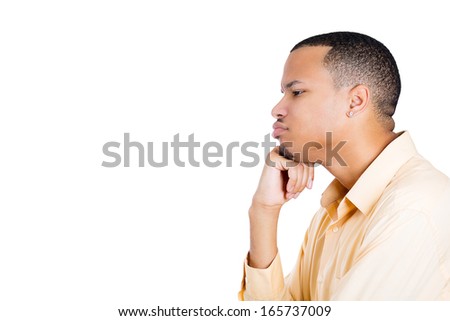 Closeup portrait of young man thinking daydreaming deeply about something with chin on hand looking confused, isolated on white background, space to left. Human emotion facial expressions feelings