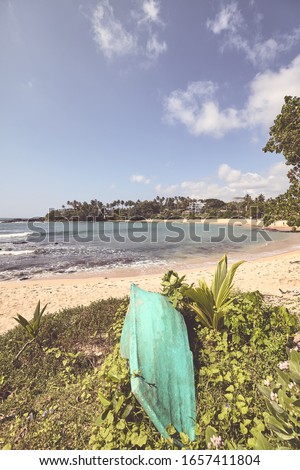 Retro color stylized picture of a tropical beach with a small boat.
