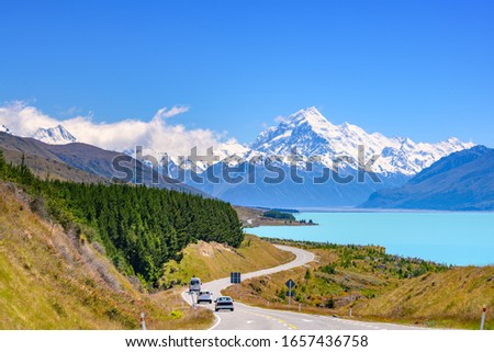 The road curves along Lake Pukaki and Mount Cook on a clear day at Peter's Lookout in the South Island of New Zealand. Royalty-Free Stock Photo #1657436758