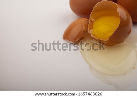 Broken chicken egg on a white background. Close up.