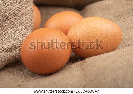 Chicken eggs on a background of rough homespun fabric. Homemade preparations, rustic treats. Close up.