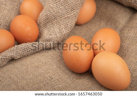 Chicken eggs on a background of rough homespun fabric. Homemade preparations, rustic treats. Close up.