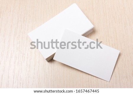 two stacks of white business cards side by side on a wooden background. close up