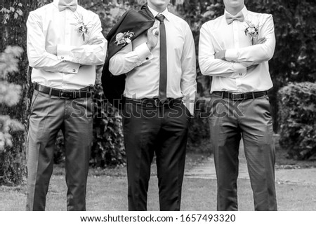 Young groom posing with his friends in park at springtime  Royalty-Free Stock Photo #1657493320