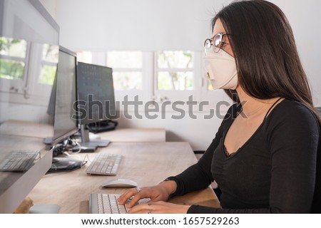Coronavirus. Woman at the office sick with mask for corona virus. Business women wear masks to protect and take care of their health. Home working with computer. Working from home.  Royalty-Free Stock Photo #1657529263