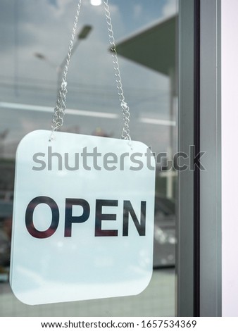 White open sign hanging on the glass door of coffee shop vertical style.