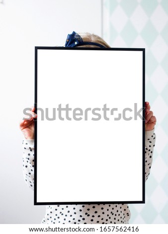A girl is holding a frame with plain background