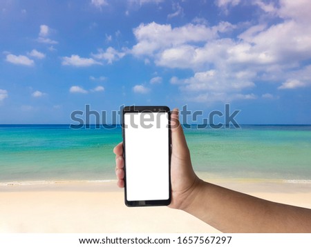 Smart phone  in hand on beach background