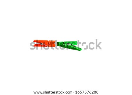 Two clothes pegs, orange and green on a white background