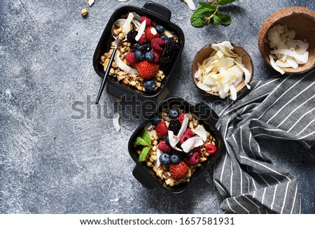 Granola with nuts, honey and berries for breakfast. Breakfast on the kitchen table, top view with place for text.
