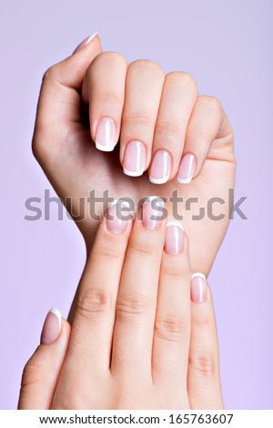 Beautiful woman's hands with beautiful  nails after manicure salon with french manicure Royalty-Free Stock Photo #165763607