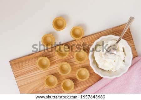 Tartlets with custard or cottage cheese. Empty tartlets or pie on a white table. Food lay flat. The view from the top. The concept of preparing food for the holiday table.