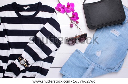 fashion. fashion sweater, jeans, bag and sunglasses on a white wooden background