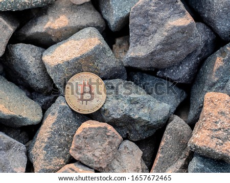 golden bitcoin on the stones. yellow btc on the rocks. gold coin beautiful. Stock photo. Crypto mining currency, miner