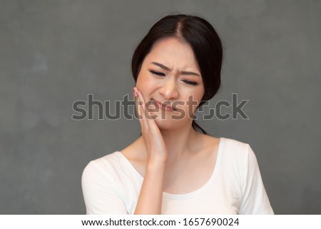 woman with toothache; sick asian woman suffering from toothache, tooth decay, tooth sensitivity, wisdom tooth pain, cavity, dental care concept; young adult asian woman model Royalty-Free Stock Photo #1657690024