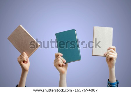 group of raised people hands holding books isolated against the colorful background, share knowledge and study