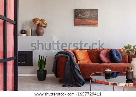Stylish living room interior with trendy sofa with pillows, real photo