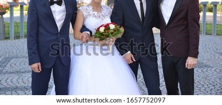married couple together with the guests are taking a wedding picture