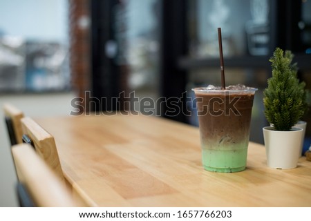 Mint and chocolate cold drink to plastic glass, put on a wooden table