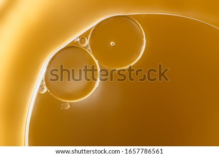 Close up ,oil drops floating on water surface  ,With  yellow background