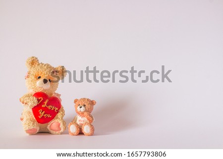 Two decorative ceramic bears holding quotes``I love you`` and ``I miss you`` in quotes.Bears are in the lower left corner of the image