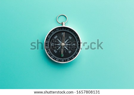 flat lay of compass on light blue background. Royalty-Free Stock Photo #1657808131