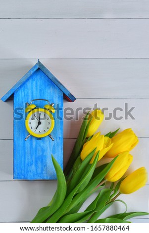 yellow tulips and a bright blue birdhouse on a pink background. picture for packages.Spring mood. Spring card for Mother's Day, Women's Day. Template greeting card for Valentine's Day.copy space.