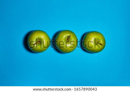 Green apple on blue background. Flat lay, top view, copy space . Food dietary concept.