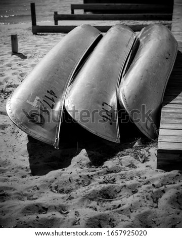 Three canoes that are just waiting to be used in black and white