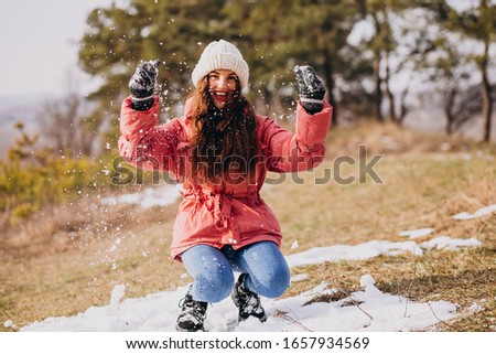 Young woman in winter park happy
