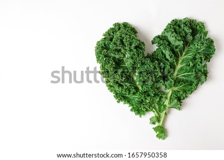 Leaves of fresh green kale  shape heart on a white background. Isolate. Place for text Royalty-Free Stock Photo #1657950358