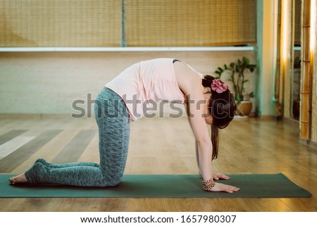 Young athletic brunette practicing a lesson in yoga, breathing, meditation posing in the frame. Wellbeing and health concept