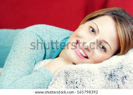 Young woman casually dressed, laying on the bad, inside her room.