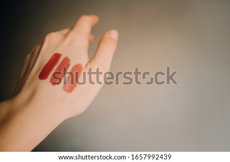 Swatch of tonal foundations of different colors on the girl’s hand