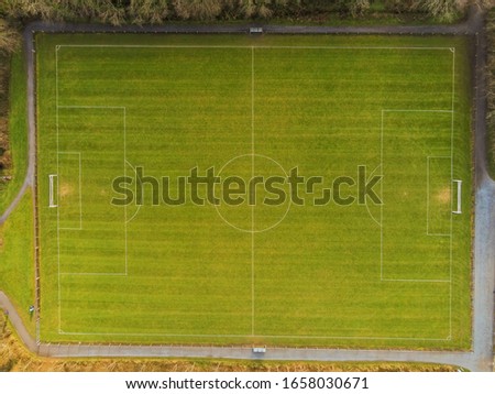 Aerial top down view on a football pitch with trees shadows. Nobody.
