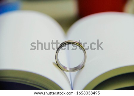 Wedding ring casting a heart-shaped shadow on the diary page,Valentine ring