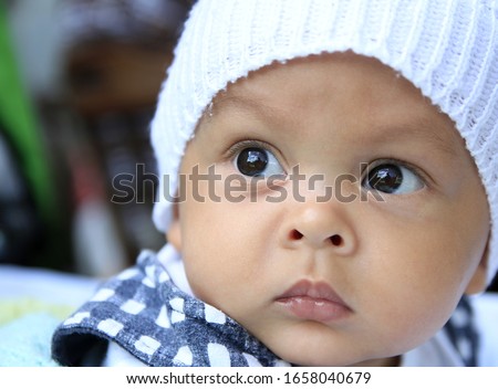 little baby looking with hat on his head after having a good sleep stock photo